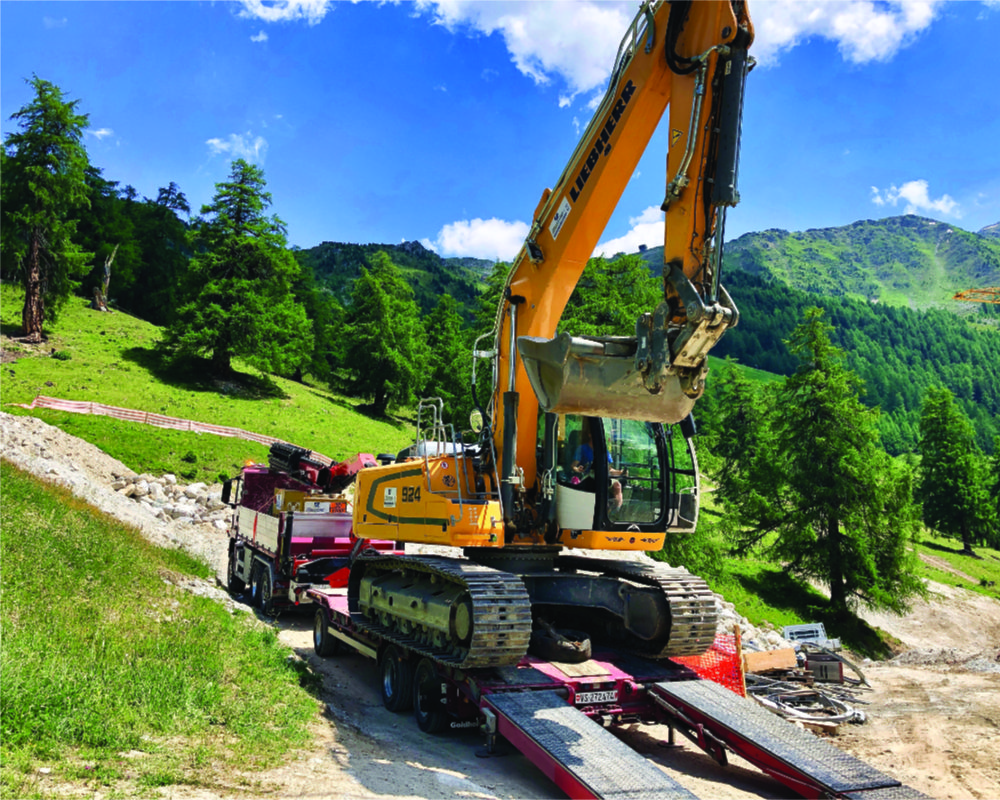 Camion d'André BORNET Fils Transports SA transportant une pelleteuse à Aproz (Nendaz) en Valais et en Suisse